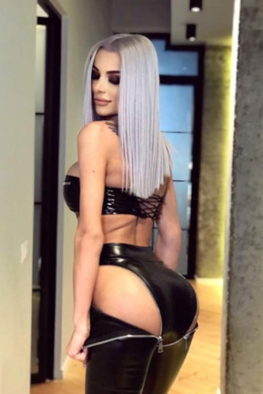 Cindy showing off her bum while wearing a latex bodysuit. 