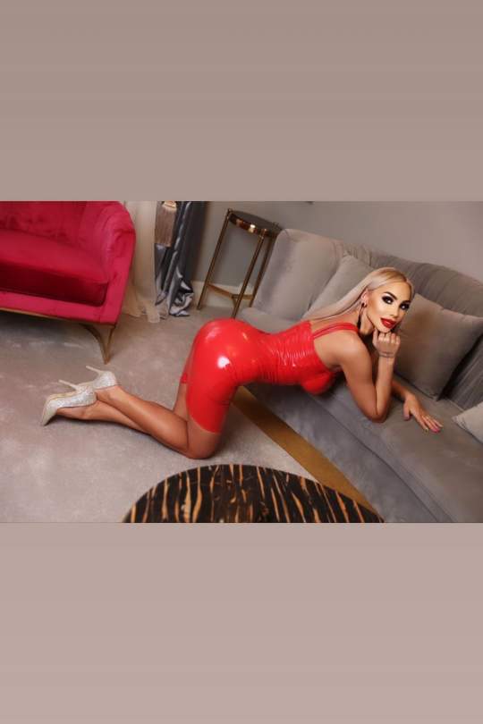 Anya showing her bum in a tight red latex dress. 